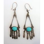 A pair of white-metal earrings set with horizontal cabochon turquoise stones (The cost of UK postage