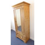 A late 19th / early 20th century waxed pine single wardrobe; the outset cornice above a central