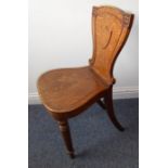 A mid-19th century oak hall chair having shield-shaped vacant cartouche and turned tapering legs