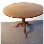 A large George III period circular-topped tilt-top mahogany occasional table, turned stem and on