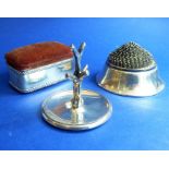 A small silver group to include an early 20th century silver-sided pincushion having hinged lid, one