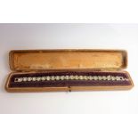 A white-metal bracelet centrally set with white cut stones (cased) (The cost of UK postage via Royal