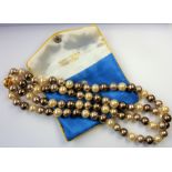 HARRIET WHINNEY; a double string of pearls with a gold-plated clasp together with matching earrings,