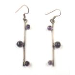 A pair of earrings each set with three cabochon amethysts (boxed)