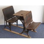 A late 19th/early 20th century stained-pine infants' school desk with cast-iron supports and the