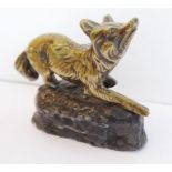 An early 20th century model of a prowling brass fox upon a heavy lead rockwork-style base (7.5cm