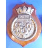 A Royal Navy ship's crest, HMS Scylla; mounted on a stained-mahogany shield (the shield 23cm high)