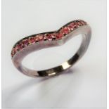 A V-shaped silver ring set with small pink stones