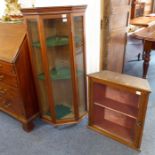 An Edwardian walnut display cabinet having a central rectangular door flanked by canted glazed