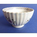 A late 18th century English porcelain tea bowl of fluted design and hand-decorated with sprigs