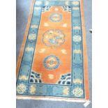 A hand-knotted Chinese rug; the blue border with Shou characters and bats etc. surrounding a burnt-