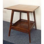 An Edwardian mahogany square-topped occasional table on pierced square tapering splayed legs