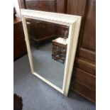 A large and modern white and gilt-embellished wall-hanging looking glass having frame and hand-