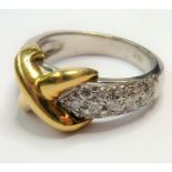 An 18-carat gold and platinum 'kiss' ring set with diamonds; ring size M/N (total weight 9.23g) (The