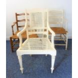 A white-painted open armchair with rattan-caned back and seat, together with two similar low