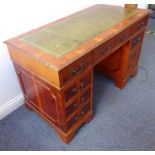 A reproduction Georgian-style yew-wood pedestal desk; the gilt-tooled green-leather inset moulded