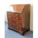 An early 20th mahogany writing bureau in Georgian-style; the angular fall opening to reveal fitted