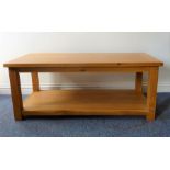 A heavy modern solid oak coffee table with cleated ends and square legs united by a potboard-style