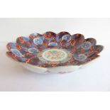 A Japanese flower-head shaped porcelain dish hand-gilded and decorated in the Imari palette, three-