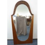 A large and impressive wall-hanging mirror; the arched top rail pressed decorated with flower heads,