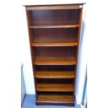 A modern mahogany set of open shelves; the shelves and uprights with reeded edges and above a