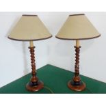 A pair of faux-walnut barley-twist table lamps together with shades