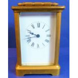 A brass and glass carriage clock; white enamel dial with Roman numerals (11.5cm high)