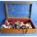 An oak display case with glazed top together with the various costume jewellery