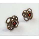 A pair of Celtic-style earrings each set with a central dark-red stone (boxed)