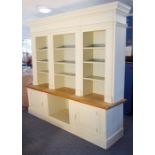 A large cream and green-painted natural oak display case; dentil cornice above shelf space and two