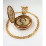 An unusual early 20th century triple photograph locket with two circular hinged covers enclosing a