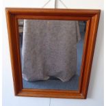 A pine-framed looking glass; the plate with hand-bevelled edge and rounded corners (frame size 107cm
