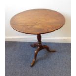 A George II period circular elm-topped occasional table of good colour, turned stem and on tripod