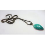 A silver-mounted tear-shaped pendant set with a polished turquoise hardstone, suspended from a