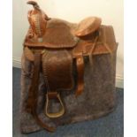 An ornately embossed brown-leather Western saddle with pad and girth