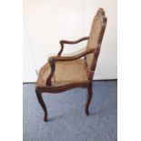 A carved open-armed walnut fauteuil (probably mid-18th century Louis XV period), rattan-caned back