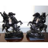 A pair of late 19th/early 20th century black-painted spelter models of warriors on horseback (