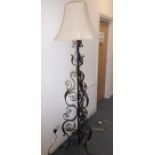 A wrought-iron lamp standard and shade on tripod base
