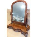 A 19th century serpentine-fronted mahogany swing mirror