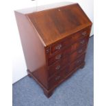 A reproduction mahogany bureau; the cleated fall opening to reveal a fitted interior of pigeon-holes