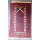 A 20th century Baluch prayer rug, predominately red ground (142cm x 87cm)