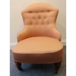 A late 19th century button-back upholstered low nursing style chair on turned front legs terminating