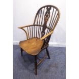 A mid-19th century comb-back Windsor armchair; wheel-back splat, shaped elm saddle-seat and turned
