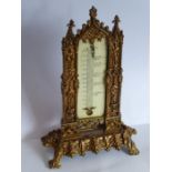 A 19th century cast gilt-metal thermometer stand in high Gothic style; with ivory register plate but