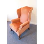 A Queen Anne style pink-velour upholstered wing-backed armchair on short cabriole mahogany legs