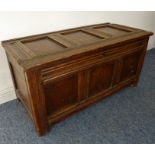 A late 17th/early 18th century panelled oak chest; the three-panelled top with iron butterfly hinges