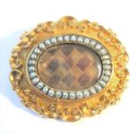 A 19th century mourning brooch set with hair and half pearls (14g) (The cost of UK postage via Royal