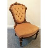 A 19th century walnut-framed and pink velour button-back upholstered nursing chair on turned
