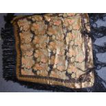 An early 20th century shawl; fine floral decoration in gold-coloured thread and with long black