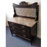 An early 20th century mahogany and marble-topped washstand; the carved back above outset marble